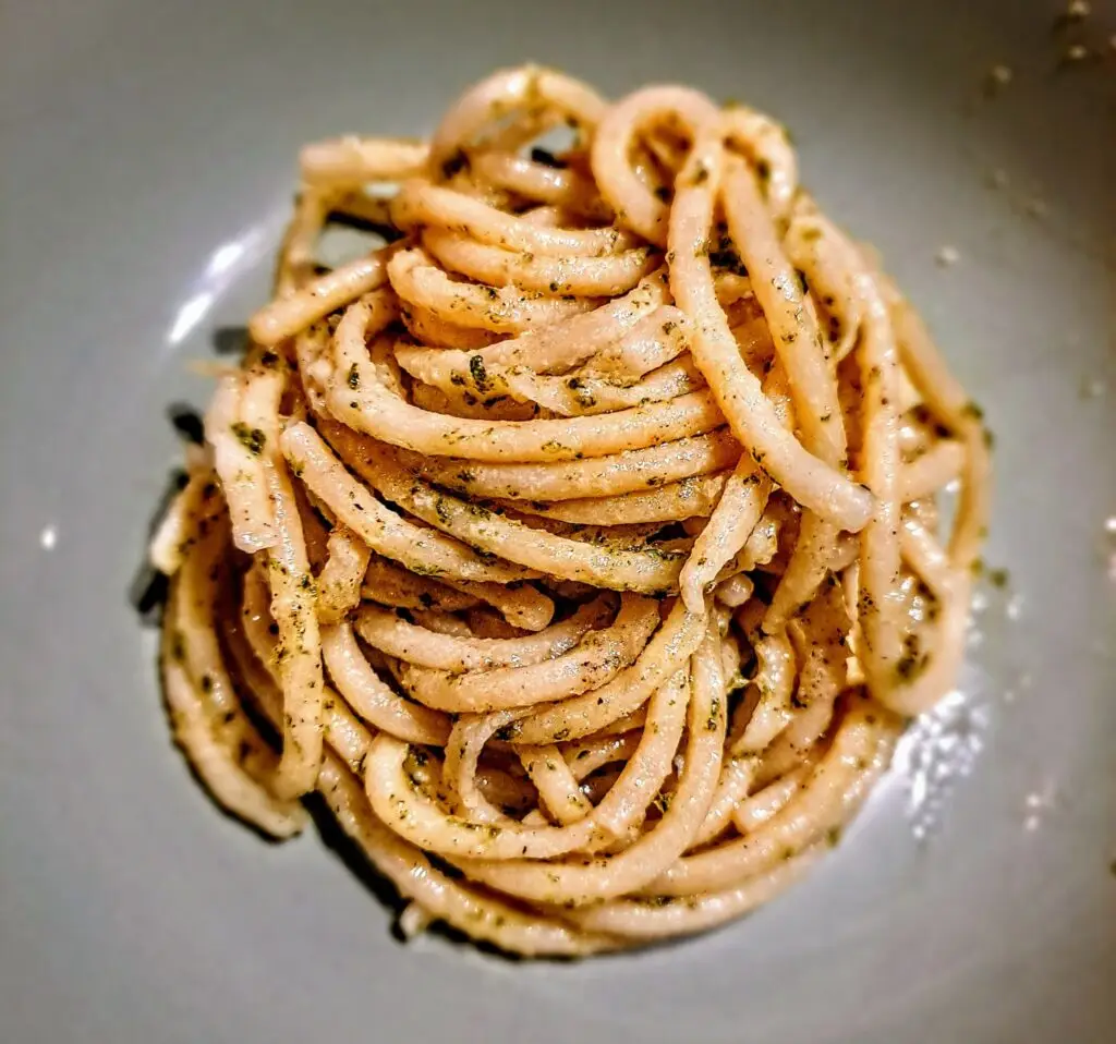 Bord met pici in kruidenpesto, van bovenaf gefotografeerd