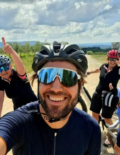 Selfie van lachende fietser met twee vrouwen op een witte grindweg
