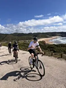 Fietsers op een grindpad langs de Portugese Atlantische kust met strand
