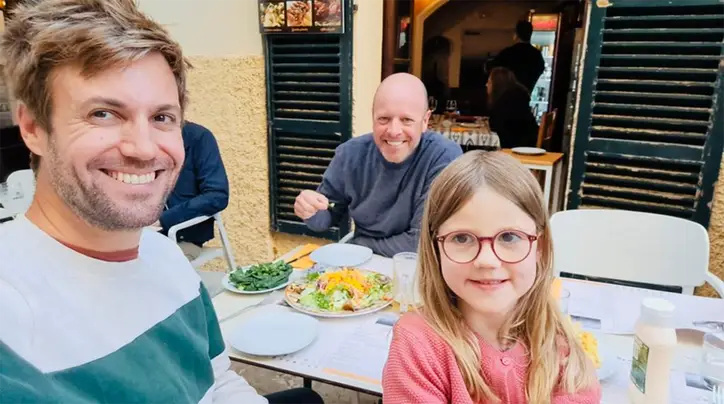 Ken en Mark met een meisje aan tafel op een terras
