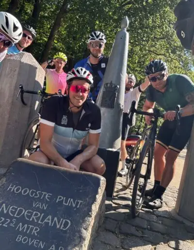 Fietsers bij de steen Hoogste punt van Nederland, 322,5 meter boven NAP