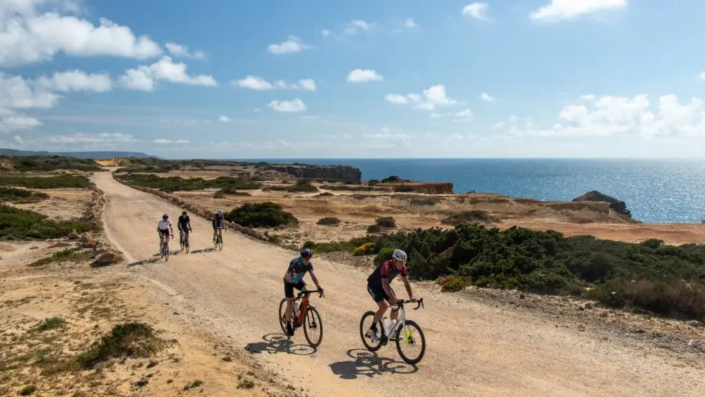 Vijf fietsers op een zandweg langs de kliffen aan de Atlantische kust