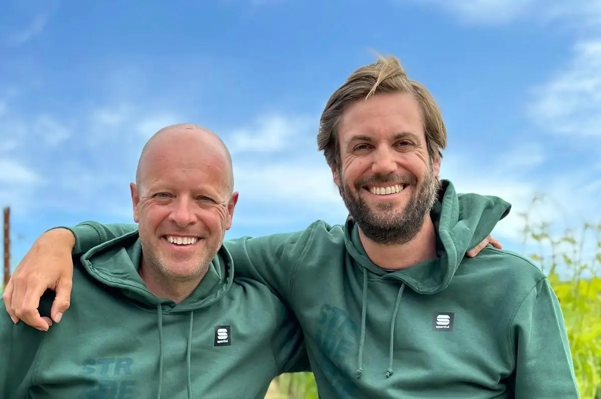 Ken en Mark lachend met de arm om elkaar heen