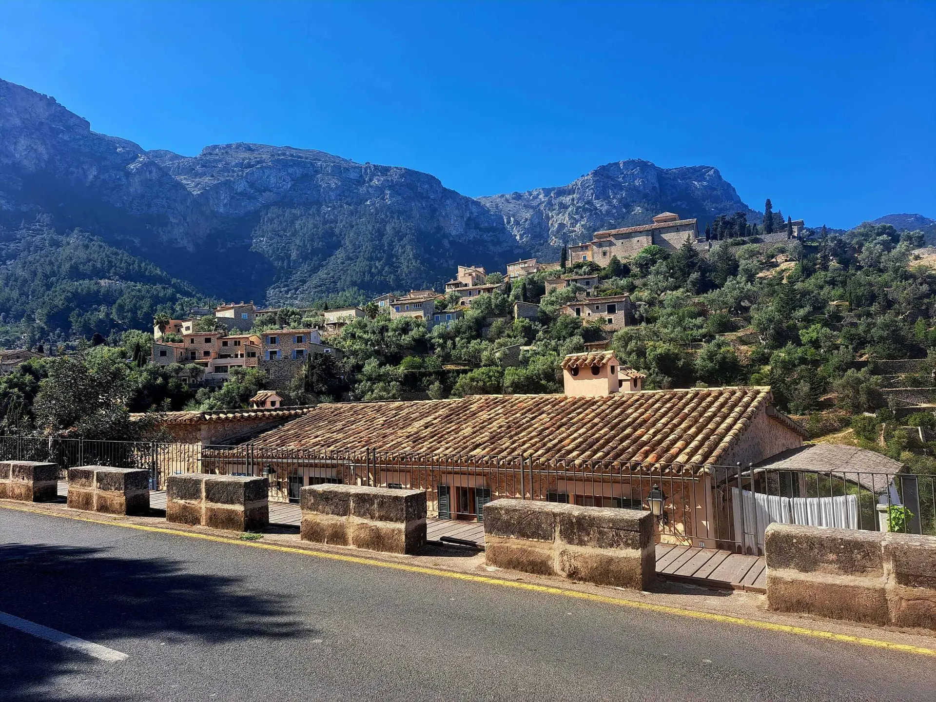 Bergdorp met stenen huizen tegen de Serra de Tramuntana, gezien vanaf de weg